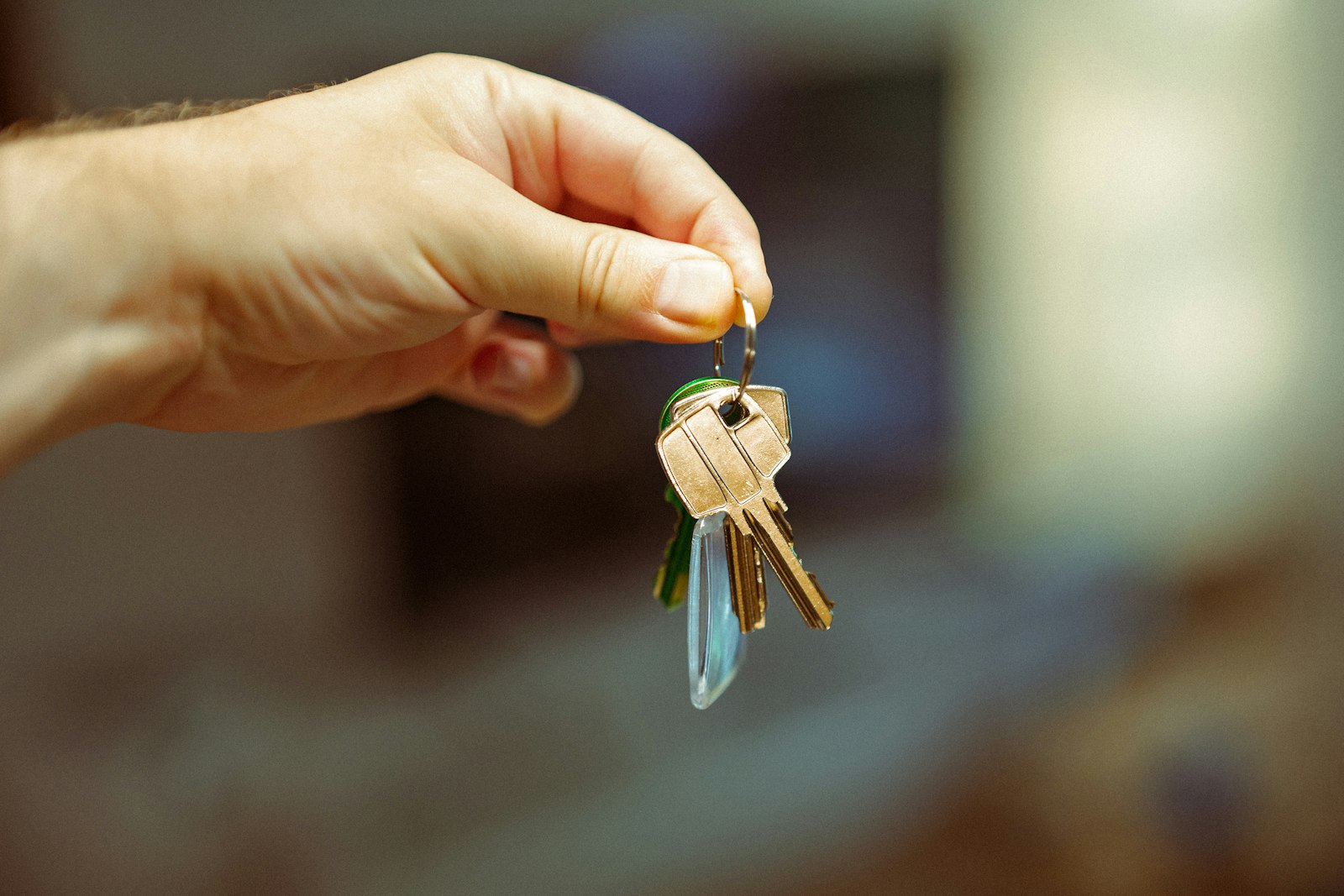 Hands holding an Australian visa approval letter and house keys